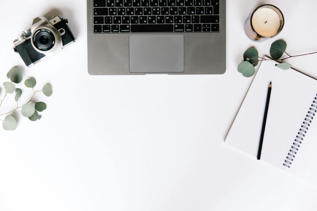 overhead shot of a laptop beside a candle