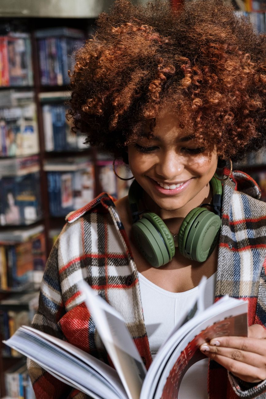 smiling woman in plaid shirt wearing green headphones